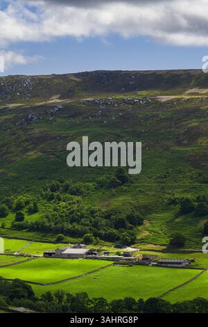 Malerischer Blick über sonnendurchflutetes Tal und Farmland bis zu den unteren Hängen von Simon's Seat (blauer Himmel) - von Skyreholme, Yorkshire Dales, England, Großbritannien. Stockfoto