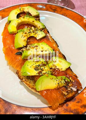 Geräucherter Lachs, Avocado, Samen und Olivenöl auf Toast. Stockfoto