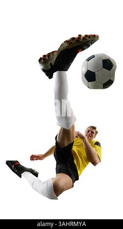 Junger Mann, Fußballspieler, der mitten in der Luft in einen kraftvollen Kick springt, im energiegeladenen Design mit Cut-out-Design vor weißem Hintergrund. Stockfoto