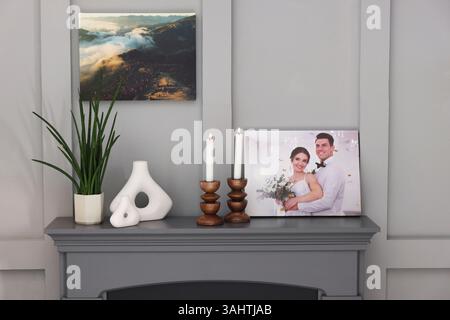 Leinwand mit bedrucktem Foto und Dekor am Kamin im Innenbereich Stockfoto