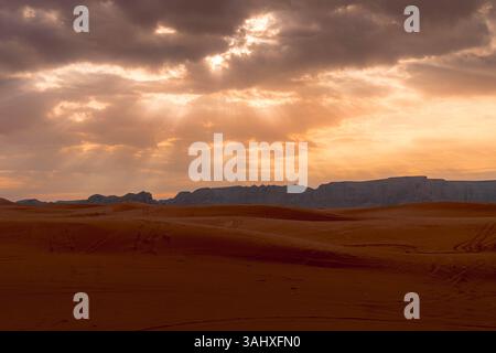 Atemberaubender Panoramablick auf leuchtende rote Dünen in der Nähe von Red Sand, Saudi-Arabien, getaucht in goldenes Wüstenlicht. Stockfoto
