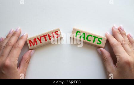 Symbol für Fakten oder Mythen. Konzeptwort Fakten oder Mythen auf Holzblöcken. Geschäftsmann Hand. Schöner weißer Hintergrund. Business and Facts or Myths Concept Stockfoto