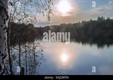 Herbstlandschaft - Waldfluss und gelbliche Herbstbäume am Herbstabend Stockfoto
