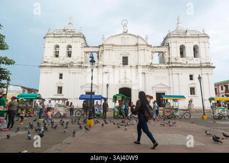 Straßenverkäufer, fliegende Tauben und Menschen vor der Kathedrale von Leon. Leon, Nicaragua. Stockfoto