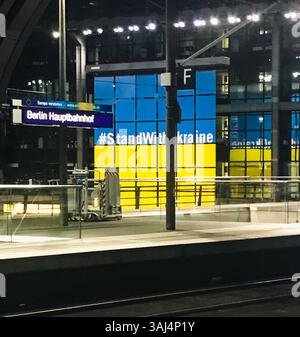 Bahnhof mit einem gelben und blauen Schild mit der Aufschrift Stand with Ukraine. Das Schild ist auf einem Gebäude Stockfoto