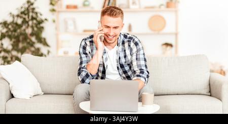 Portrait von lächelndem Kerl mit pc sprechen auf Handy Stockfoto