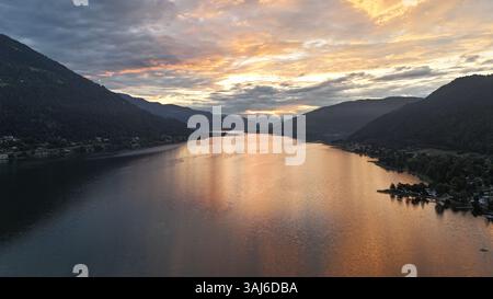 Sonnenuntergang aus der Vogelperspektive über den Ossiachsee in Kärnten, Österreich, umgeben von Bergen und Dörfern Stockfoto