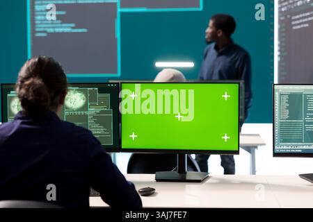 Hacker-Team arbeitet mit einem Green-Screen-Layout am Computer im Überwachungsraum Regierungszentrum, High-Tech. Qualifizierte Spezialisten, die Daten für Cyber-Kriegstaktiken und nationale Sicherheit studieren. Stockfoto