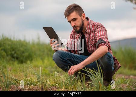 Farmer Plantage Qualitätsprüfung durch Tablettenlandwirtschaft modernes Technologiekonzept Smart Farming. Stockfoto