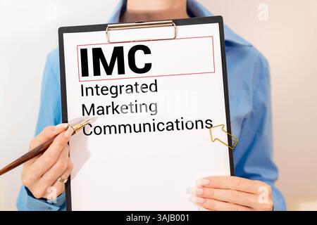 IMC-Konzept – integrierte Marketingkommunikation Schreiben Sie auf Haftnotizen, die auf einem Holztisch isoliert sind. Stockfoto