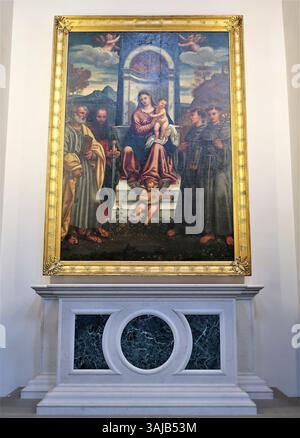 Dieses Gemälde, das Francesco Vecellio zugeschrieben wird, zeigt die thronende Madonna mit dem Heiligen Peter, dem Heiligen Paulus, dem Heiligen Franz von Assisi und dem Heiligen Antonius von Padua. Er wurde um 1520 erbaut und ist in Öl auf Leinwand ausgeführt und befindet sich im Bode Museum, Berlin. Stockfoto