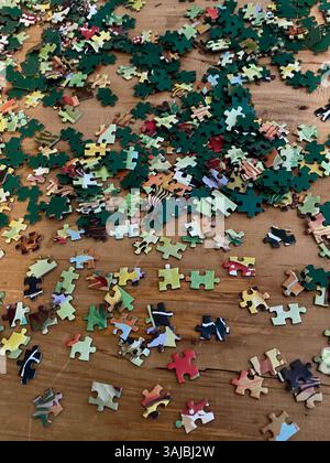 Verstreute Puzzleteile auf Holztisch Stockfoto