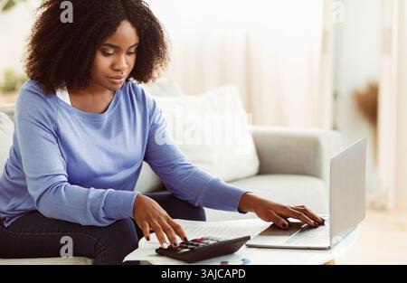 Frau mit Rechner und pc zu Hause Stockfoto