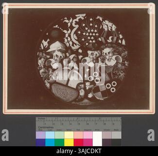 Diese Buntglasscheibe aus dem Jahr 1891 zeigt zwei Wappen und drei Helme mit unterschiedlichen Wappen: Eine Kugel, einen Speer und zwei Arme. Das Kunstwerk spiegelt die heraldischen Traditionen der Zeit wider. Stockfoto