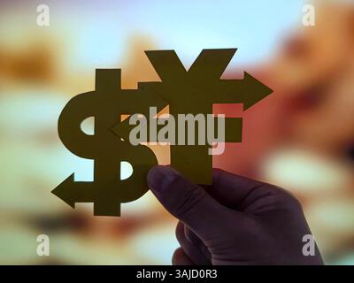 SUQIAN, CHINA - 11. APRIL 2025 - ein Foto zeigt eine Person, die am 11. April 2025 in Suqian, Provinz Jiangsu, China ein Währungssymbol für den chinesischen Yuan und den US-Dollar hält. Stockfoto