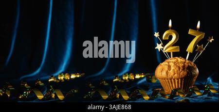Coming Age Party 27. Geburtstag. Schokoladen-Cupcake mit Nummer 27 Kerze auf samtblauem Hintergrund. Banner Stockfoto