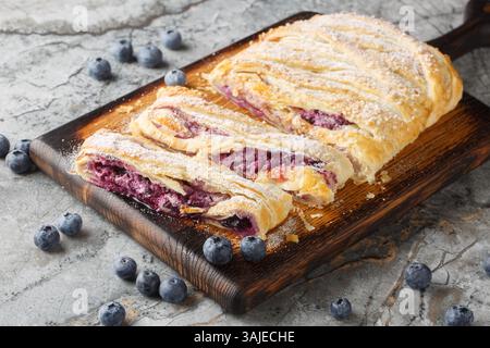 Blätterteig mit frischer Heidelbeere und Frischkäse Füllung in Nahaufnahme auf Holzbrett auf dem Tisch. Horizontal Stockfoto