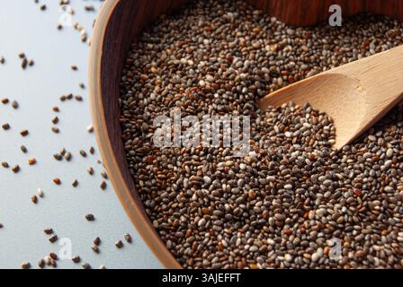 Chiasamen in einer herzförmigen Holzschale mit einem Holzlöffel. Stockfoto