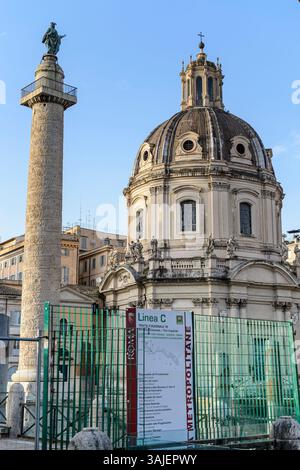 Die Trajan-Säule, die Kirche des Allerheiligsten Namens Maria im Forum Trajan mit einem Schild, das auf Bauarbeiten an der U-Bahn-Linie C in Rom hinweist, 29. März 2025. Stockfoto