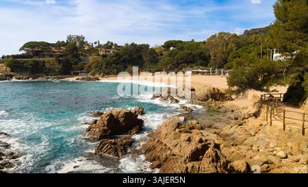 Blick vom Küstenpfad in der Nähe von Blanes, Blick auf den Strand Cala Sant Francesc über die felsige Küste und das türkisfarbene Meer. Stockfoto