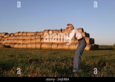 Junge Frau, die auf dem Land fotografiert Stockfoto