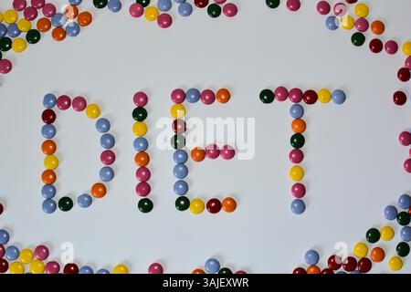 Candy-Diät-Konzept. Wortdiät aus runden Schokoladenbonbons auf weißem Hintergrund. Ungesunde Ernährung Stockfoto