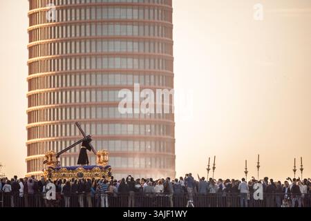 Sevilla, Spanien, 25. März 2016, Nuestro Padre Jesus Nazareno macht eine feierliche Reise über die Triana-Brücke in Sevilla, eingerahmt vom modernen Torre Sevilla Stockfoto