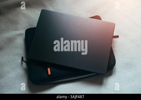 Hintergrundbild des weißen Bettes mit Laptop und Tasche. Arbeiten Sie von zu Hause aus. Nomad Life Concept. Stockfoto