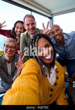 Selfie einer Gruppe glücklicher Geschäftsleute, die mit einem Telefon Fotos machen Stockfoto