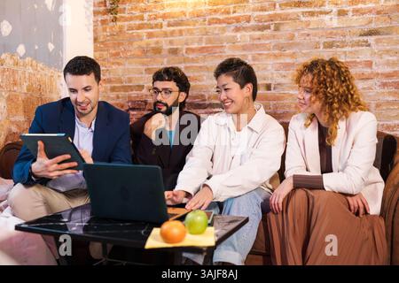 Multiethnisches Team arbeitet gemeinsam an Projekten mit Laptop und Tablet Stockfoto