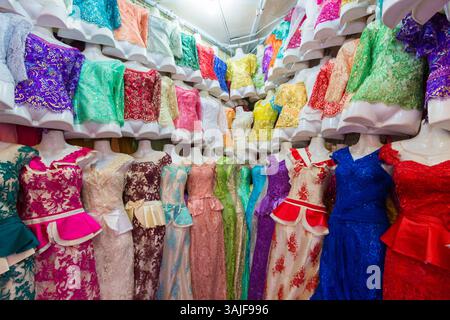 Schaufensterpuppen zeigen in einem Bekleidungsgeschäft eine lebhafte Kollektion von Spitzenkleidern. Stockfoto