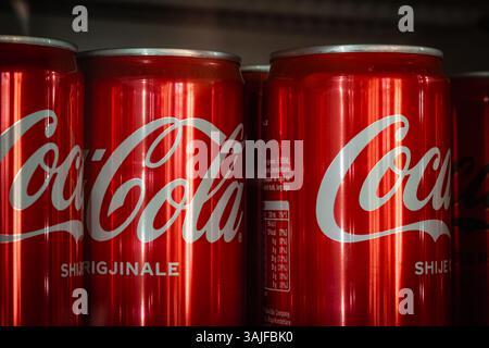 Coca-Cola-Soda-Dosen in einem kommerziellen Kühlschrank mit Cola Classic Original. Aluminiumdosen mit alkoholfreiem Getränk Coca Cola Classic auf den Regalen von Stockfoto