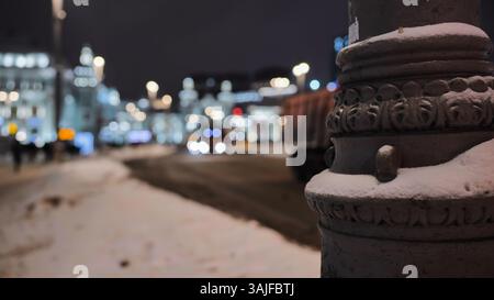 Schneebedeckender kunstvoller Lampenpfosten in Moskau bei Nacht mit verschwommenem Hintergrund Stockfoto