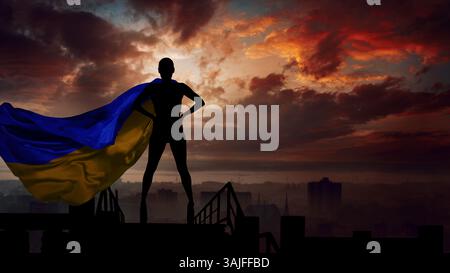 Ukrainisches Heldenkonzept. Frau mit ukrainischer Flagge hinter ihrem Rücken als Superheldin in cape. Stockfoto