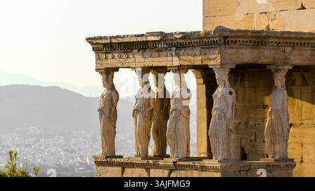 Sonnenuntergang über weiblichen Statuen in der Karyatidenhalle des Erechtheion auf der Akropolis, Athen, Griechenland Stockfoto