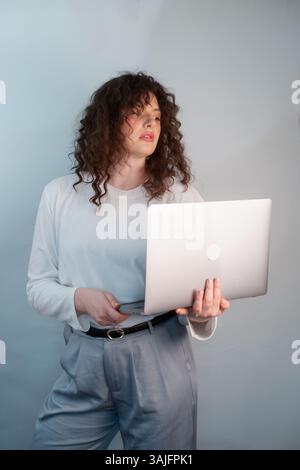 Eine selbstbewusste Geschäftsfrau, die den Komfort zu Hause und die Arbeit miteinander in Einklang bringt, hat ein Online-Meeting mit einem Kunden direkt von ihrem Laptop aus. Stockfoto