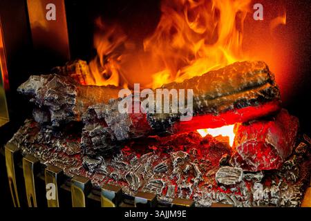 Künstlicher elektrischer Kamin mit orangefarbener, roter und gelber Flamme. Nahaufnahme des Feuers. Gemütliches romantisches Licht Stockfoto