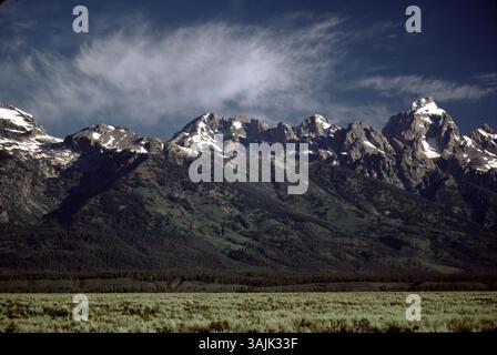 Grand Teton National Park, WY. USA 5/1995. Der Grand Teton ist der höchste Berg der Teton Range. Die Bezeichnung dieser wunderschönen Bergkette wird französischsprachigen Trappern des 19. Jahrhunderts zugeschrieben – Les trois tétons (die drei Zitzen) wurde später anglizisiert und auf Tetons verkürzt. Der Park hat zahlreiche Seen. Obwohl in einem Zustand der Rezession ein Dutzend kleiner Gletscher in den höheren Lagen in der Nähe der höchsten Gipfel des Gebirges bestehen. Einige der Felsen im Park sind die ältesten, die in einem amerikanischen Nationalpark gefunden wurden und wurden auf fast 2,7 Milliarden Jahre datiert. Stockfoto