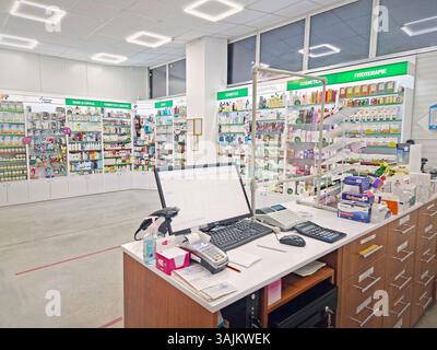 UNGHENI, MOLDAWIEN - 20. JANUAR 2024 Blick in eine Apotheke mit Verkäuferschalter, Computer und Kasse vor Lagerregalen mit Medikamenten. Stockfoto
