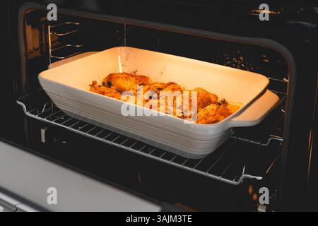 Hähnchenschenkel werden im Ofen perfekt gebraten und werden goldfarben und saftig. Stockfoto