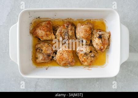 Frisch gebackene Hähnchenschenkel aus dem Ofen, zart und saftig in der eigenen Brühe. Stockfoto