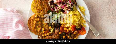 Ein nahrhaftes, herzhaftes Frühstück mit Linsenzucchini-Pfannkuchen, Hirse, gebackenem Hähnchenhals, gebratenen Süßkartoffeln, Brokkoli, Karotten, Kichererbsen, mit einem F Stockfoto