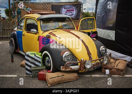 Ein maßgeschneiderter mehrfarbiger Volkswagen Beetle Rat Rod mit verrosteter Patina und Vintage-Accessoires auf einem Autofest ausgestellt. Stockfoto