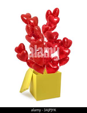 Helle, herzförmige Ballons fliegen aus der gelben Box auf weißem Hintergrund Stockfoto