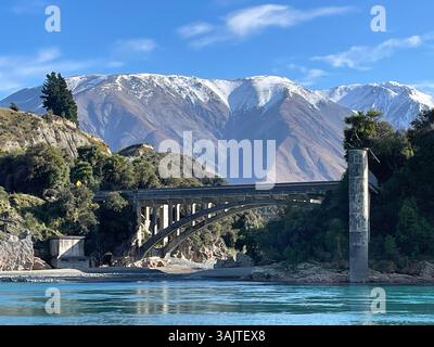Eine Brücke, ein Fluss und schneebedeckte Berge auf der Südinsel Neuseelands Stockfoto
