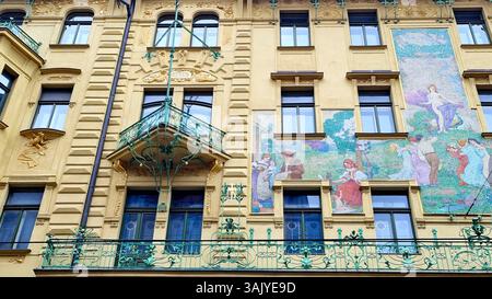 Fragment einer Jugendstilfassade mit bunten Mosaikpaneelen, Stuck mit Vergoldung und anmutigen Balkonen in Prag, Tschechische Republik Stockfoto
