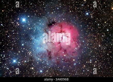 Trifidennebel (M20), optisches Bild. Dieser Nebel ist eine Region der Sternentstehung. Der rote Bereich ist ein Emissionsnebel, in dem die Strahlung heißer, neu gebildeter Sterne das umgebende Gas ionisiert und zum Leuchten bringt. Der blaue Bereich ist ein Reflexionsnebel, der kein Licht abgibt, sondern das Licht naher Sterne reflektiert. Reflexionsnebel erscheinen blau, weil kurzwelliges blaues Licht mehr als rot gestreut wird. Die dunklen Linien über dem Nebel werden durch dunkle Staubwolken im Vordergrund verursacht, die das Licht von hinten verdecken. Der Nebel liegt im Sternbild Sagittarius. Stockfoto