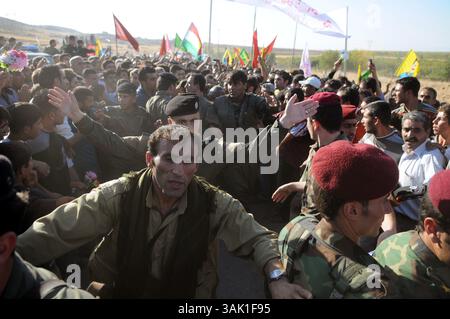 18. Oktober 2009 - Zakho, Irak - Ein PKK-Guerillas kämpft sich auf dem Weg zur Grenze zwischen Irak und Türkei durch die Menge von Unterstützern. Acht kurdische Rebellen sind vom Irak aus in die Türkei eingedrungen, um sich als Zeichen der Unterstützung für Friedensbemühungen aufzugeben. Die PKK-Militanten verließen ihre Zuflucht in den Qandil-Bergen und wurden von Flüchtlingen aus dem Flüchtlingslager Makmur im Irak begleitet, bevor sie in die Türkei einreisten. (Kreditbild: © Kamaran Najm/ZUMA Press) Stockfoto