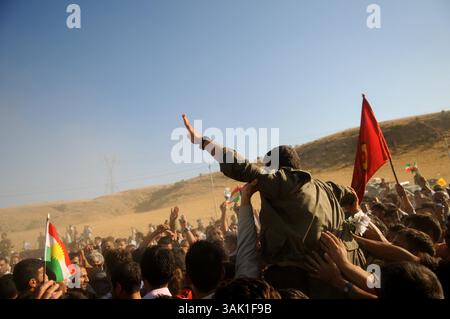 18. Oktober 2009 - Zakho, Irak - Ein PKK-Guerilla wird von irakischen kurdischen Unterstützern hochgehalten. Acht kurdische Rebellen sind vom Irak aus in die Türkei eingedrungen, um sich als Zeichen der Unterstützung für Friedensbemühungen aufzugeben. Die PKK-Militanten verließen ihre Zuflucht in den Qandil-Bergen und wurden von Flüchtlingen aus dem Flüchtlingslager Makmur im Irak begleitet, bevor sie in die Türkei einreisten. (Kreditbild: © Kamaran Najm/ZUMA Press) Stockfoto