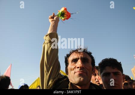 18. Oktober 2009 - Zakho, Irak - Ein PKK-Kämpfer hebt seine Hand zum Jubel der unterstützenden Menge. Acht kurdische Rebellen sind vom Irak aus in die Türkei eingedrungen, um sich als Zeichen der Unterstützung für Friedensbemühungen aufzugeben. Die PKK-Militanten verließen ihre Zuflucht in den Qandil-Bergen und wurden von Flüchtlingen aus dem Flüchtlingslager Makmur im Irak begleitet, bevor sie in die Türkei einreisten. (Kreditbild: © Kamaran Najm/ZUMA Press) Stockfoto